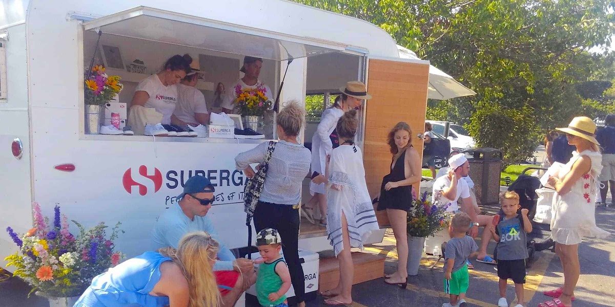 A footwear pop-up shop run from a branded marketing vehicle at an outdoor event.