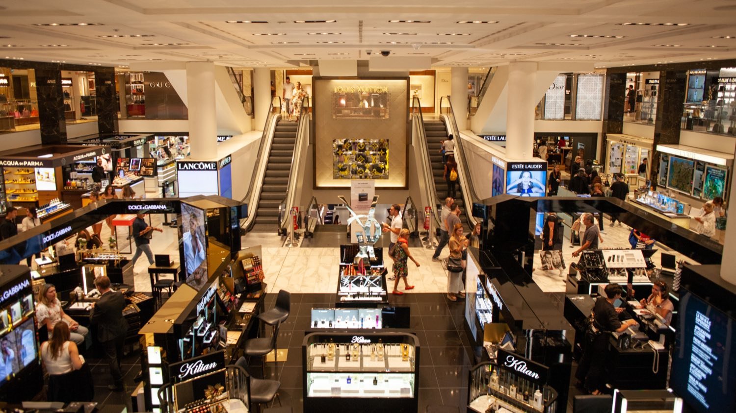 A modern shop-in-shop retail environment with curated product displays and warm lighting.